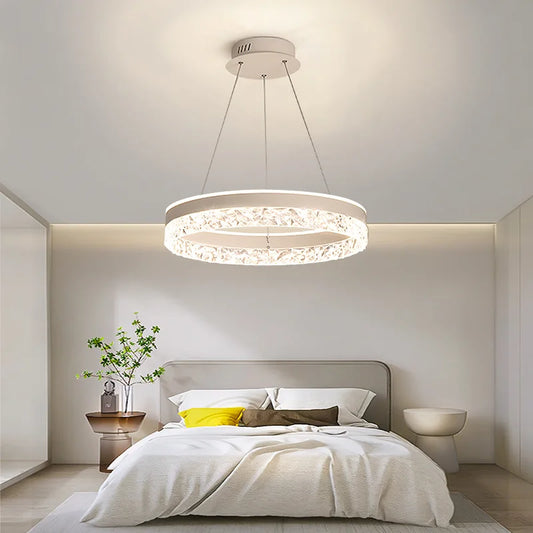Chandelier hanging above a bed in a bedroom setting