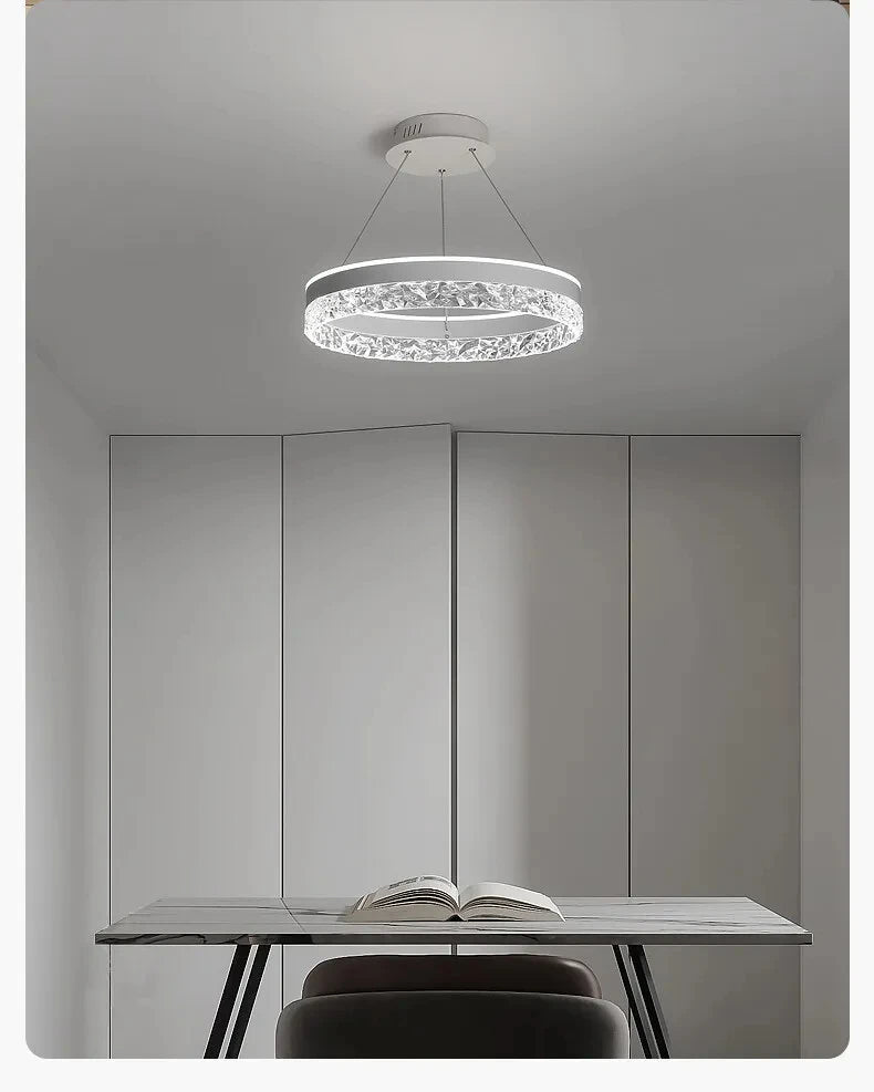 Modern ceiling light fixture in a minimalistic room with a table and chair.