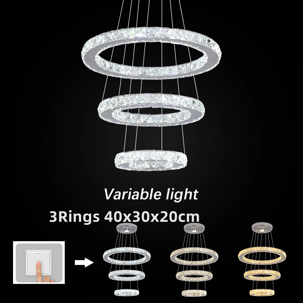 Three-tiered crystal chandelier with variable light feature on a black background