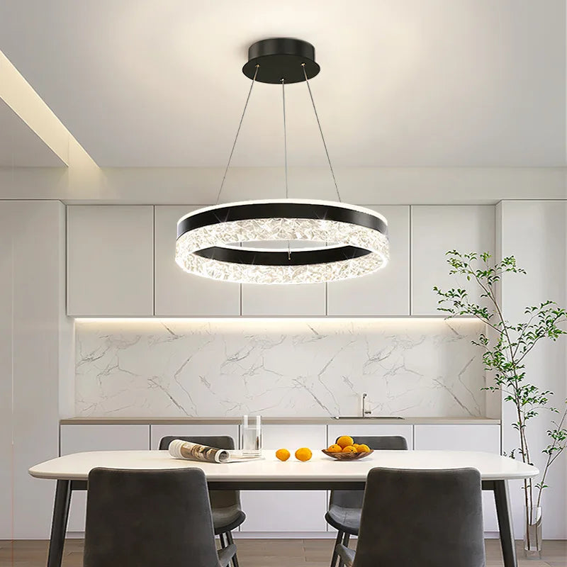 Modern chandelier hanging above a dining table in a kitchen setting.