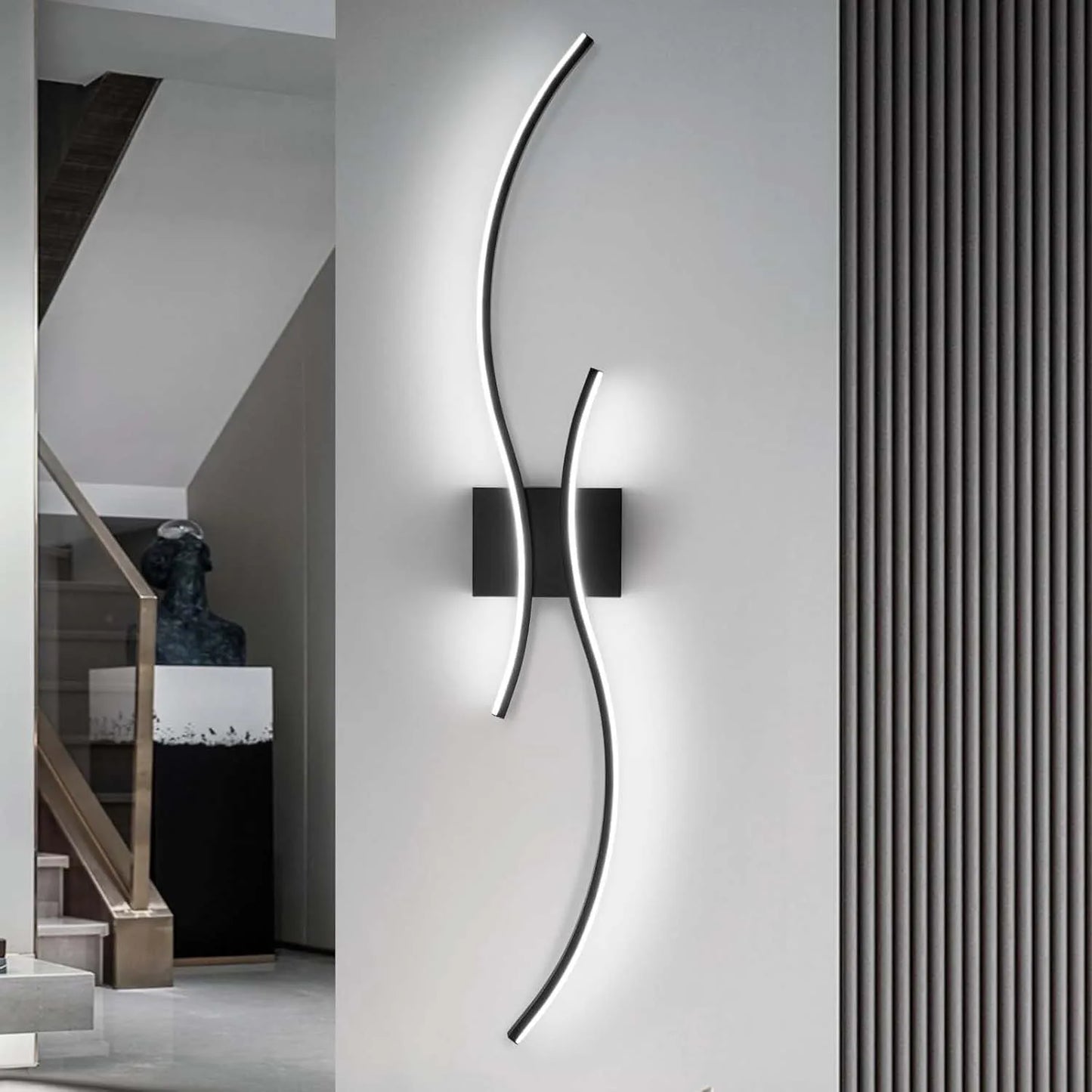 Modern wall light fixture on a gray wall with a staircase in the background