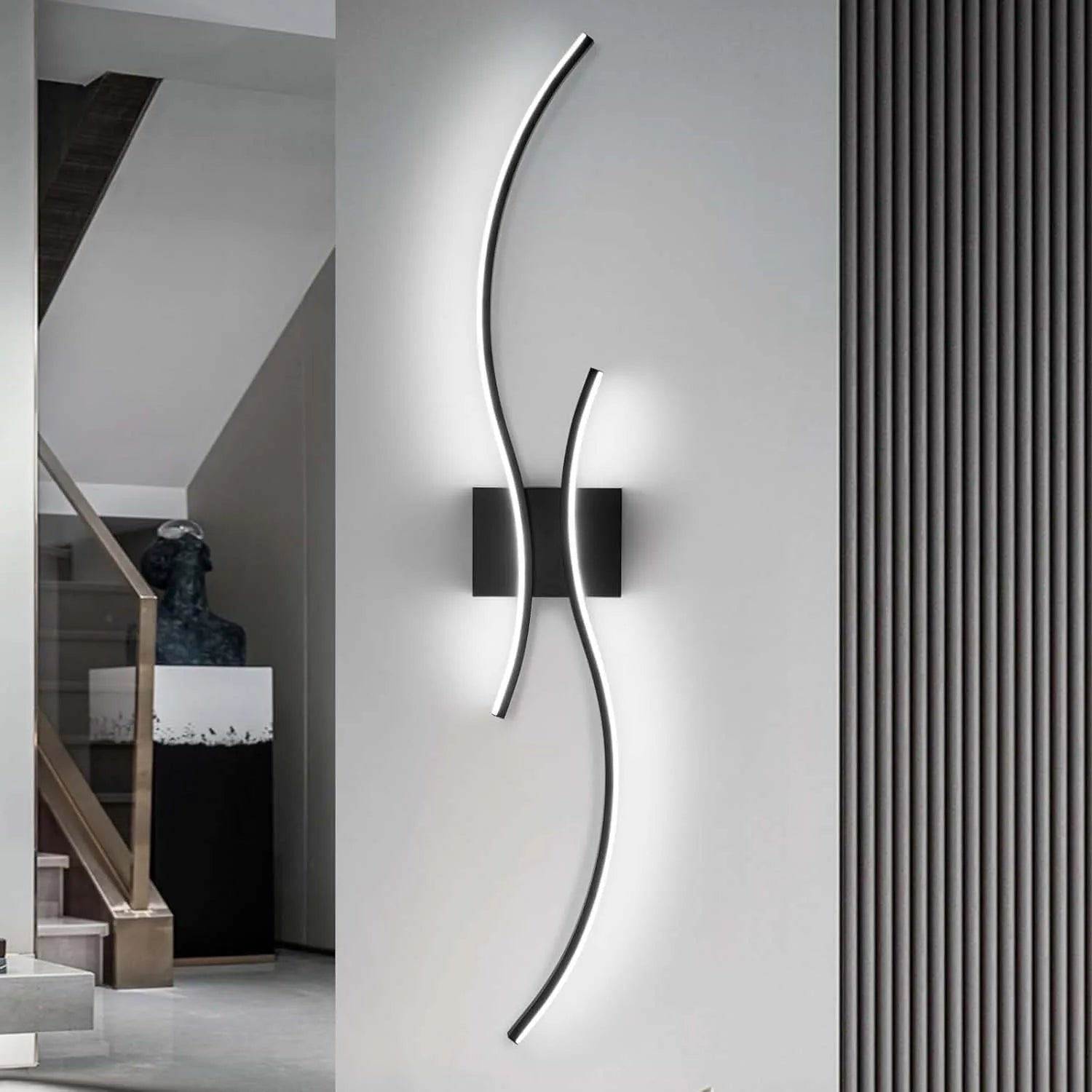 Modern wall light fixture on a gray wall with a staircase in the background