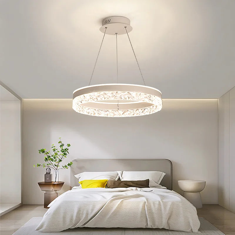 Chandelier hanging above a bed in a bedroom setting